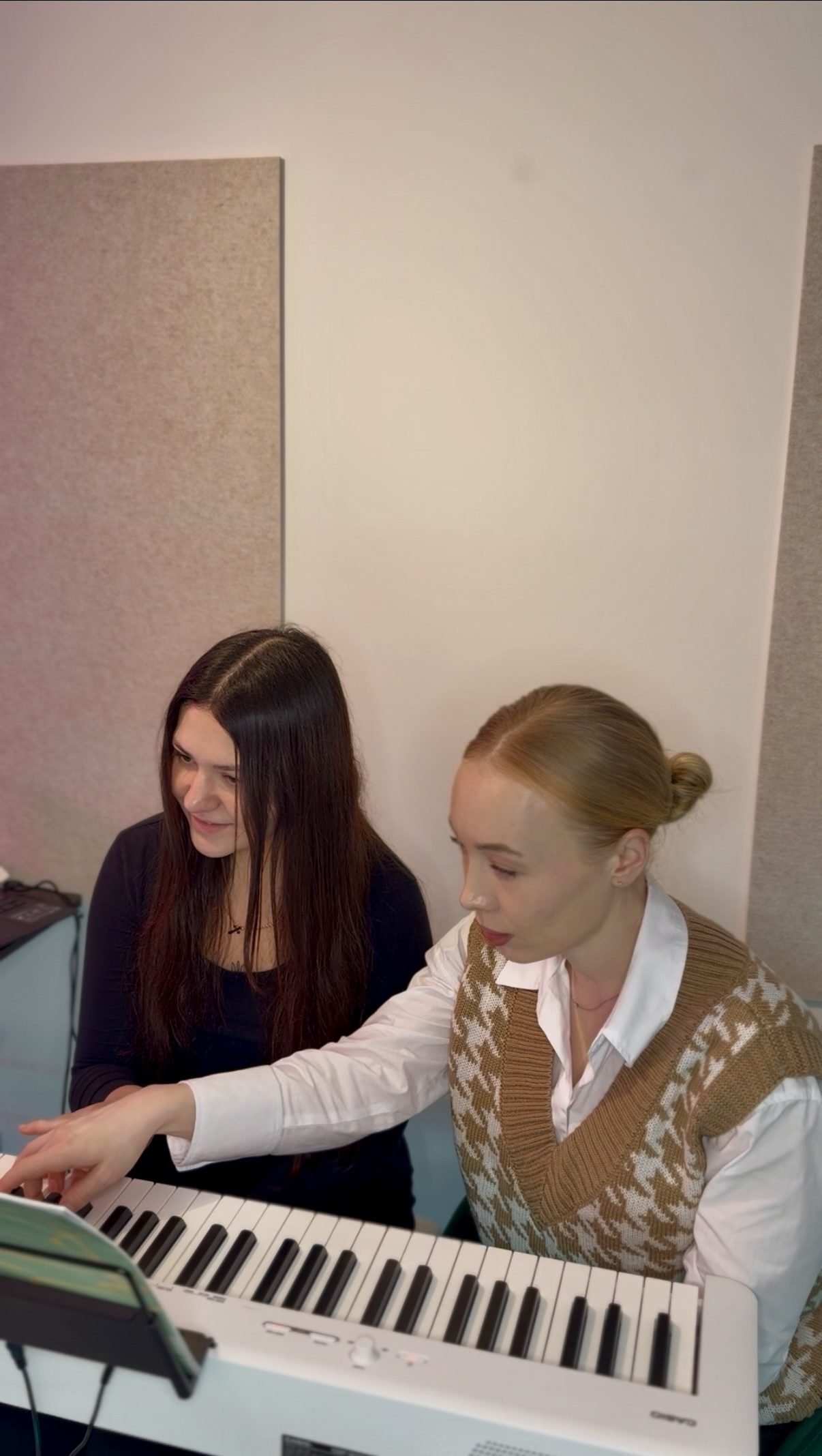 Oleksandra showing a student hand position at the keyboard during a piano trial lesson