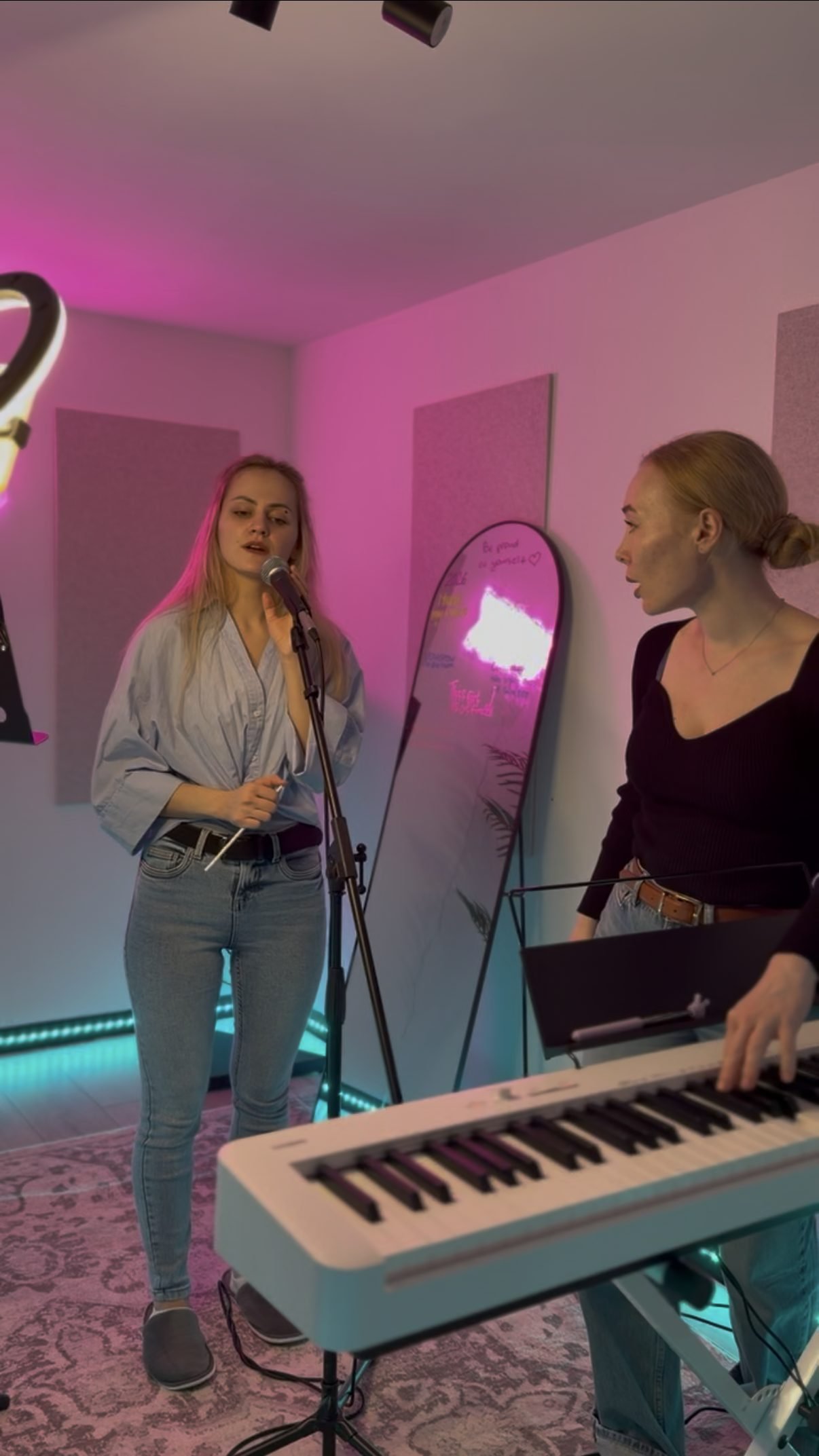 A student singing at the microphone while Oleksandra accompanies on piano during a vocal trial lesson